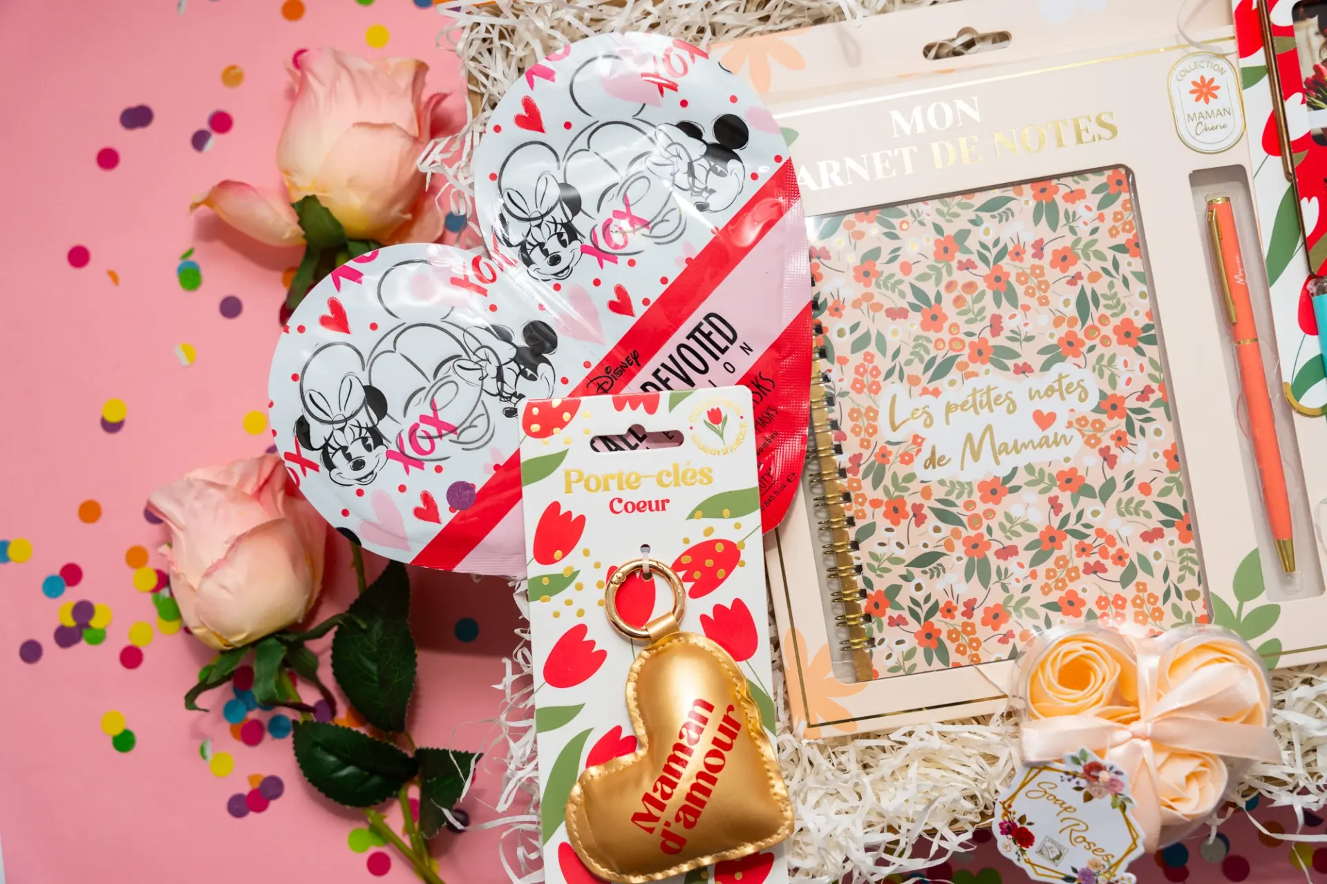 Gros plan sur les masques de soin en forme de coeur et le porte-clés doré Maman d'amour dans leur écrin de fête.