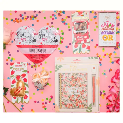 Disposition à plat des articles de la box maman incluant une tablette de chocolat blanc, un carnet de notes et un porte-clés coeur doré.