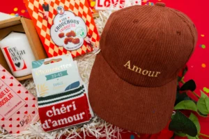 cadeau symbolique homme avec chaussettes 'Chéri', tablette de chocolat 'Je t'aime', bougie 'Live, Laugh, Love', cacahuètes, et casquette en velours personnalisée 'Amour'