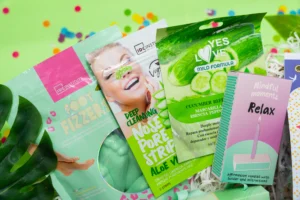 cadeau bien être femme avec bombe de bain pour les pieds, masque visage, patch nez, kit home spa avec baume à lèvres et crème pour les mains, ainsi qu’une bougie.