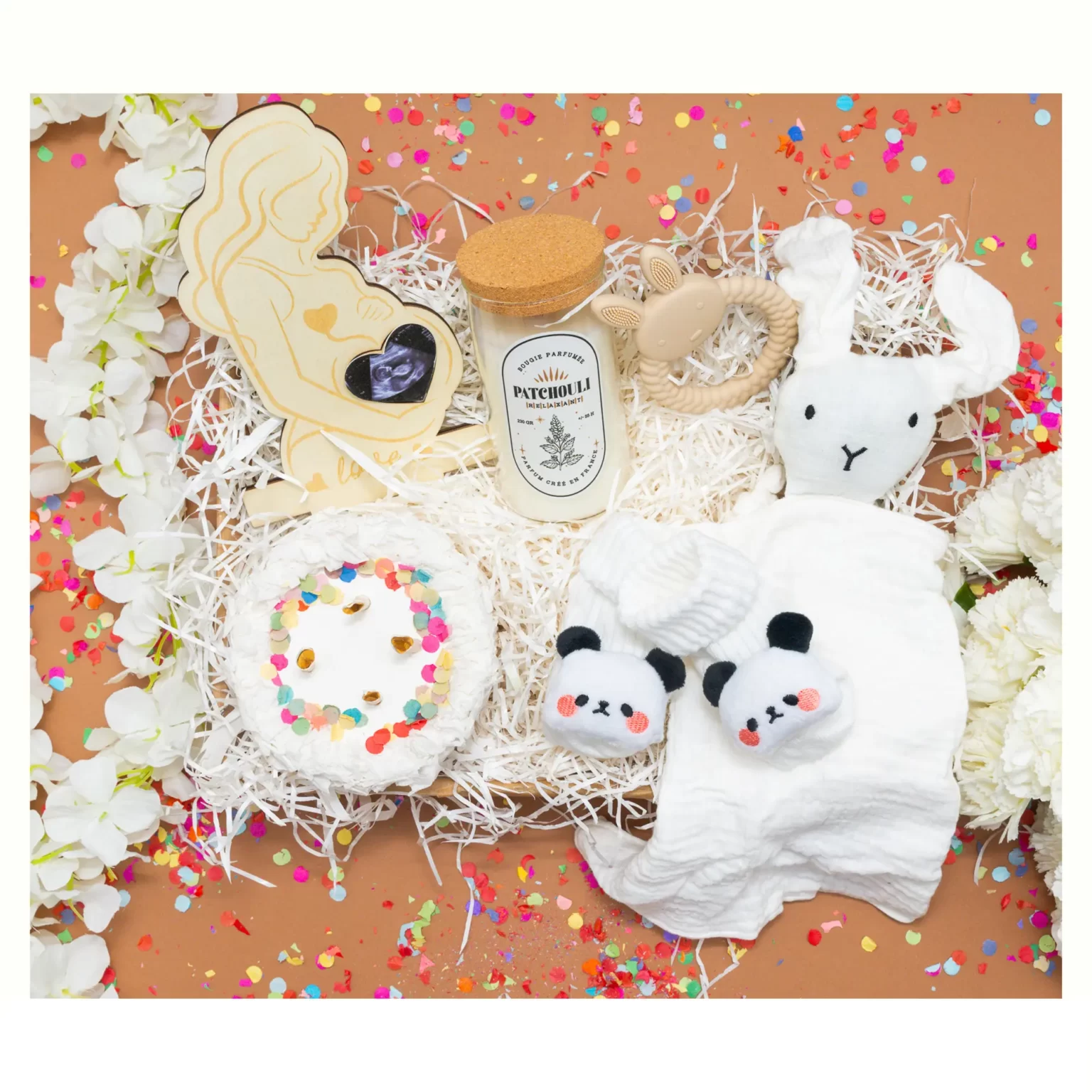 idee de cadeau future maman avec bougie, doudou , chaussettes ,anneau de dentition , cadre photo et gateau