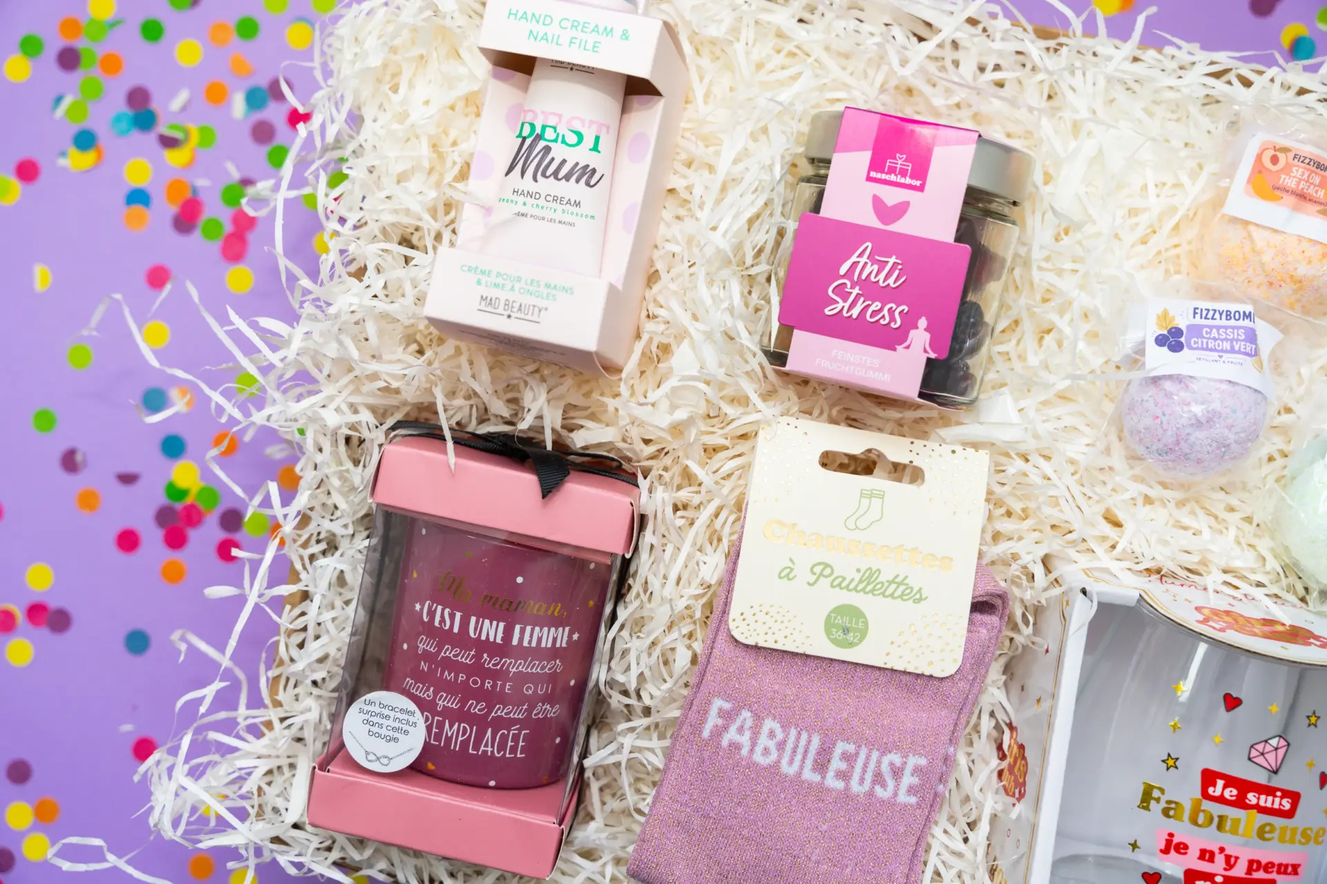 Gros plan sur une bougie parfumée avec message d'amour et des chaussettes roses scintillantes Fabuleuse dans une box cadeau.