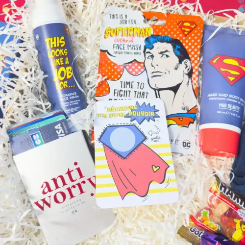 Coffret cadeau homme original comprenant savon pour cheveux et corps, mousse nettoyante visage, chaussettes Super Man, bonbons, carte à gratter ‘Super toi’ et porte-cartes original – idée cadeau homme unique et originale.
