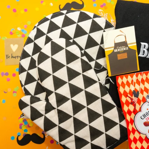 cadeau cuisine homme : une box avec tablier homme 'L'authentique Brasserie', set de gants et sous-plat pour la cuisine, et un set de gourmandises de cacahuètes et amandes