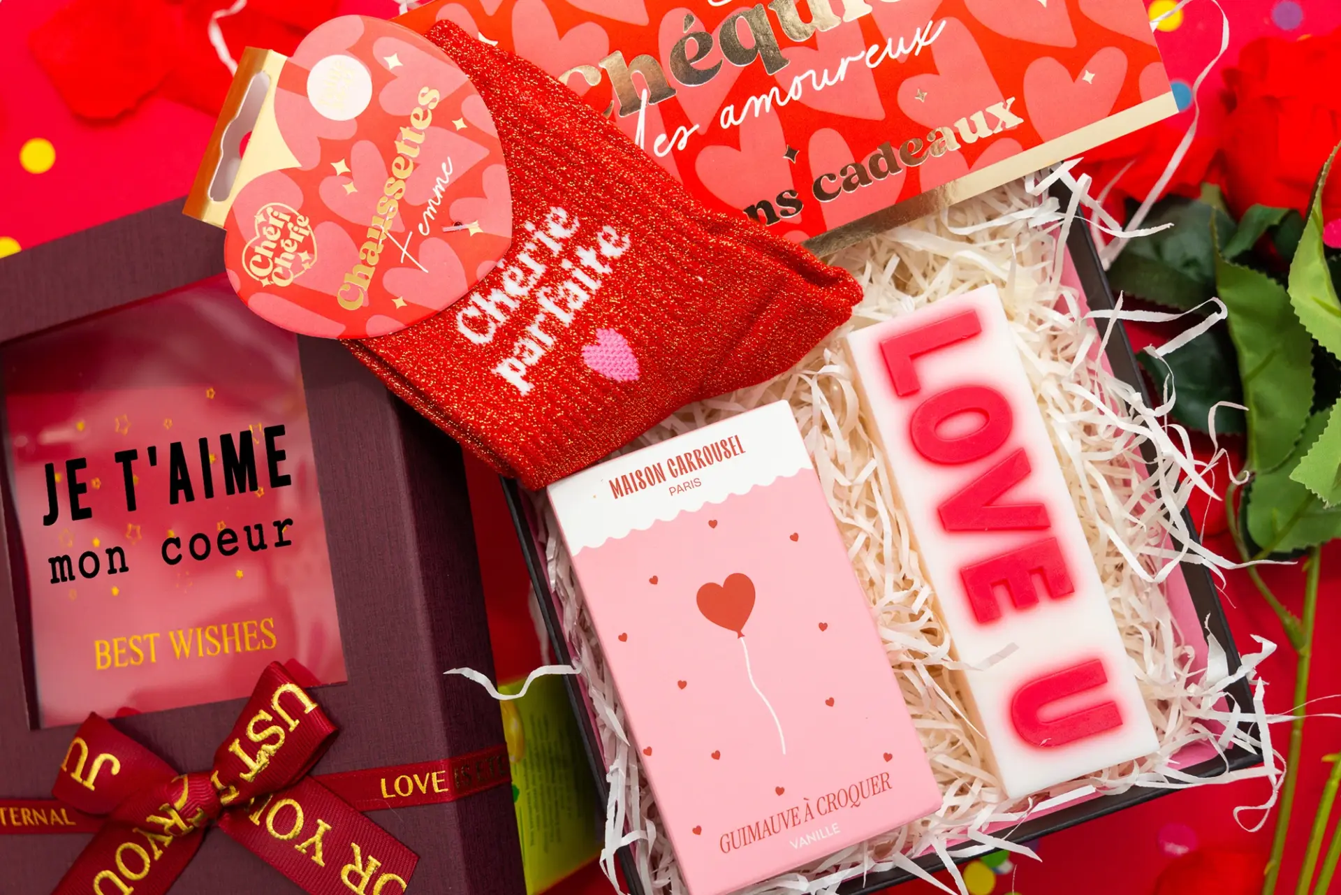 Love Box Saint-Valentin ouverte montrant une boîte cadeau romantique pour couple contenant : chaussettes rouges “Chérie parfaite”, un chéquier d’amour, une boîte de guimauves à croquer, une bougie “LOVE U” et une boite avec message “Je t’aime mon cœur”romantique