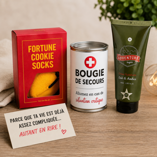 Mise en scène de produits d’un kit de survie humoristique avec chaussettes fortune cookie, bougie de secours, crème et carte drôle sur fond bois.
